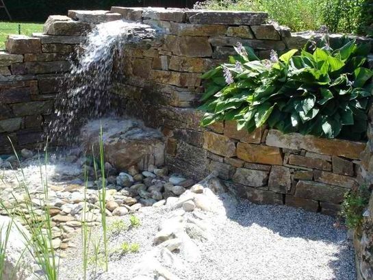 Natursteinmauer an Wasserstelle im Garten